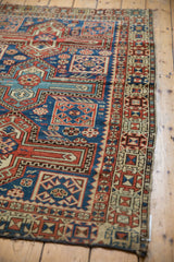 Geometric patterns, worn pile, and tattered edge in navy, madder red, saffron on antique Caucasian rug.