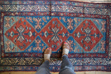 Detail of vintage Malayer runner showing geometric medallions, abrashed blue, madder red, and low pile.