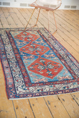 Vintage Malayer runner corner featuring ivory fringe, traditional red and blue borders, low pile.