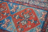 Vintage Malayer rug detail, geometric motif in madder red and abrashed aqua blue with low pile.