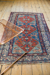 Detail view of vintage Malayer runner border with cherry red, blue geometric patterns, low pile.