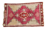 Vintage Turkish Yastik rug with raspberry red medallion, ivory field, and mountain motifs, 1'7