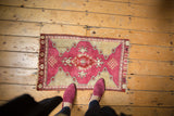 Visible central medallion and finials on a raspberry red field with antique ivory floral peaks.