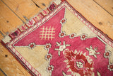 Vintage Yastik rug detail: raspberry field, ivory corner finial, and light tatter.