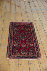 Vintage Sarouk rug's cherry red floral field, navy blue border, and intact side selvage.