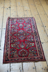 Corner of vintage Sarouk runner showing cherry red field, blossomed floral sprays, and fringe.