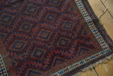 Antique Belouch rug corner with diminutive plant motifs, triple stripe border, and tattered fringe.