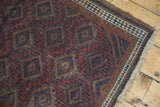 Antique Belouch rug corner showing blue concentric diamonds, wave, and diminutive plant borders.