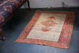 Antique Persian Malayer rug, ivory lattice field, bold red medallion, with historic patina.