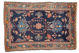 Vintage Baktiari rug, indigo blue field, outlined medallion, and blush, sky blue floral motifs.