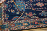 Vintage Baktiari rug corner: indigo field, blush and sky blue floral motifs, traditional border.