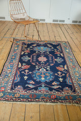 Vintage Baktiari rug low pile, secured fringe, and indigo, blush floral border.