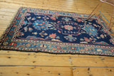Vintage Baktiari rug's dark secured edge with indigo, sky blue, and blush floral border.