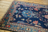Detail of vintage Baktiari rug showing indigo field, blush and sky blue floral motifs, low pile.