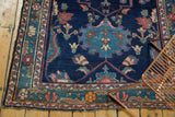 Vintage Baktiari rug close-up showing intricate floral border and indigo field with low pile.
