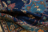 Low indigo blue pile on folded Bakhtiari rug with blush, sky blue floral motifs.
