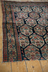 Antique Northwest Persian rug's floral border, pawn motif, madder red, and tattered edge.