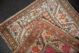 Corner of vintage Malayer rug showing front pattern and brighter colors on the hand-knotted reverse.