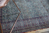 Antique Doroksh rug's detailed boteh paisley pattern and border in cochineal red and navy.