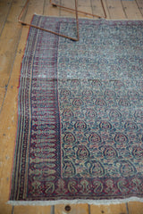 Antique Doroksh rug: cochineal red border with scrolling paisley botehs and softened ivory tones.