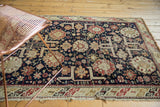 Antique Caucasian rug. Pinwheel floral, starburst patterns, navy, red, ivory. Evident knot head wear.
