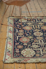 Antique Caucasian rug's geometric border with red, ivory, and navy, showing frayed edge.