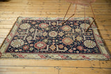 Antique Caucasian rug's tattered fringe and geometric border with visible wear to knot heads.