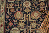 Antique Caucasian rug detail highlighting storied wear, geometric animals, and madder red on navy.