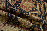 Close-up of antique Caucasian rug's detailed navy, madder red, sand geometric and animal motifs.