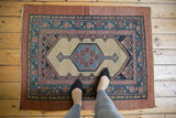 A person's overhead view of an antique Persian Serab rug, showing its scale and geometric design.
