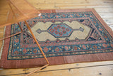 An antique Persian Serab rug displays its geometric pattern and intact raspberry red borders.