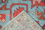 Hand knotted Oushak rug corner, contrasting blue pile with patterned ivory foundation.