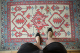 Overhead view of New Oushak rug with geometric medallion in red, blue, and ivory.