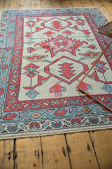 New Oushak rug corner, with ivory fringe, madder root red boteh, and faded denim blue vine motifs.