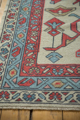 Hand-knotted Oushak rug corner, red boteh and blue meandering vine borders.