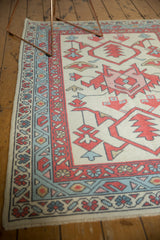 New Oushak rug corner: ivory field, madder red boteh, and faded denim blue vine borders.
