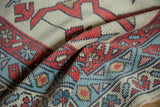Textured close-up of a new Turkish Oushak rug, with madder root red boteh and faded blue vine borders.