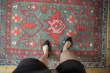 Central red palmette and blush primitive blossoms on a hand knotted Oushak rug.