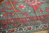 Hand-knotted Oushak rug with red boteh and vine borders on a gray field of primitive blossoms.