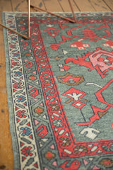 Red boteh main border, ivory meandering vine, and gray field of a Turkish Oushak rug.