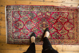 Vibrant raspberry, gold, and blue floral sprays on a vintage American Sarouk rug.