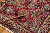 Intricate floral sprays and tight weave in raspberry, gold, and celadon on a Sarouk rug.