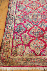 Fringe and intricate floral border of the hand knotted Sarouk runner with raspberry and gold.