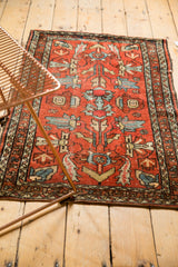 Vintage Lilihan rug's oversized floral cross sections, cherry red and sky blue, showing mostly even wear.