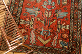 Lilihan rug showing blue, beige germinating plants on cherry red field, with visible pile wear.