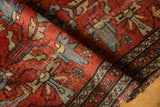 Rolled edge of the vintage Lilihan rug, showing cherry red pile, blue patterned border, and foundation wear.