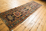 Antique Karaja runner's tattered side and geometric borders in navy, madder red, and sky blue.