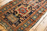 Side detail of an antique Karaja runner with geometric border, showing loss and tatter.