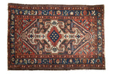 Vintage Baktiari rug: oversized rams horn medallion, floral ground in cherry red, navy, ivory.