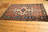 Bottom edge of Vintage Baktiari rug with lightly tattered fringe and navy, red floral border.